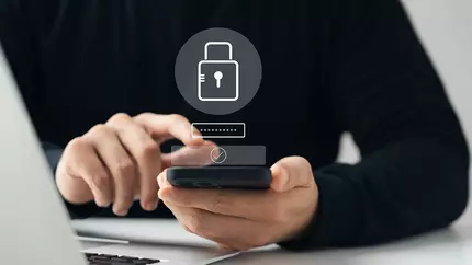 small business owner in black shirt securing mobile device and computer from cyber threats