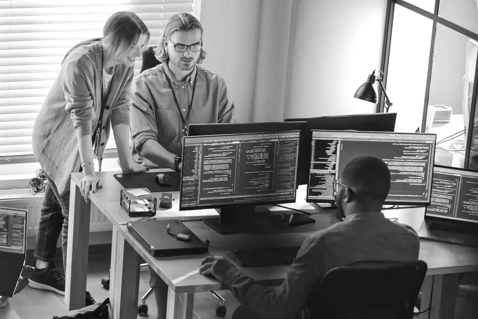IT professionals working together at desks with computers